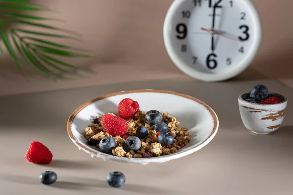 Bowl of granola with yogurt, milk and fresh raspberries, blueberries, mango for a healthy breakfast on the dark background — Stock Photo, Image