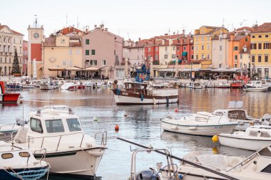 Rovinj, Hırvatistan-6 Ocak 2022: Rovinj şehir limanında demirli yelkenliler, kış günbatımında