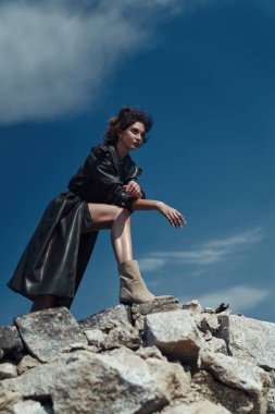 Esmer, modaya uygun bir bayan kayalıklarda yürüyüş yapıyor.