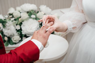 Evlilik yüzükleri. Gelin damada bir nişan yüzüğü verdi. Yakından bakınca, gelin yüzüğü damadın parmağına takıyor. seçici odak