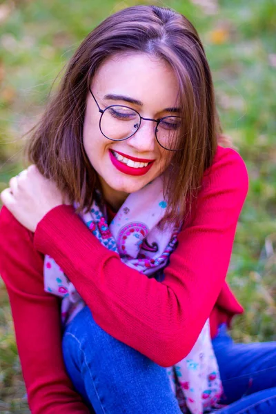 Doğada kırmızı kazaklı bir kız. Kırmızılı kız. Kırmızı dudaklı kız. Sonbahar fotoğrafı