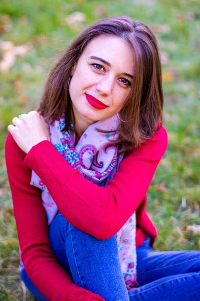 Doğada kırmızı kazaklı bir kız. Kırmızılı kız. Kırmızı dudaklı kız. Sonbahar fotoğrafı