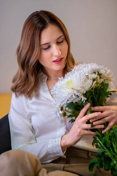 Çiçekli beyaz gömlekli kadın.