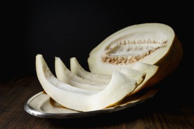 Tam ve dilimlenmiş kavun, ahşap masa zemininde ballı kavun. Çok sağlıklı, doğal, vejetaryen yiyecekler..