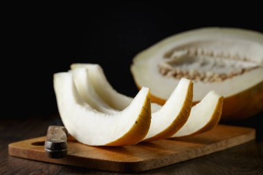 Tam ve dilimlenmiş kavun, ahşap masa zemininde ballı kavun. Çok sağlıklı, doğal, vejetaryen yiyecekler..