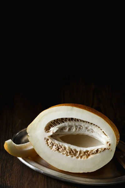 Whole and sliced melon, honey melon on wooden table background. Very healthy, natural, vegetarian food.