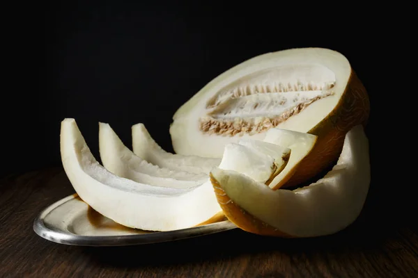 Whole and sliced melon, honey melon on wooden table background. Very healthy, natural, vegetarian food.