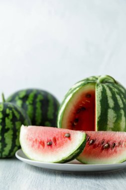Tam ve dilimlenmiş karpuz, ahşap masa arkasında ballı karpuz. Çok sağlıklı, doğal, vejetaryen yiyecekler..
