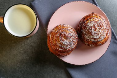 Tarçın ve hindistan cevizli limonlu çörekler gri bir masada pembe bir tabakta