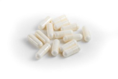 İzole edilmiş beyaz arka planda birkaç beyaz hap ya da kapsül yakın çekim. Seçici odak.