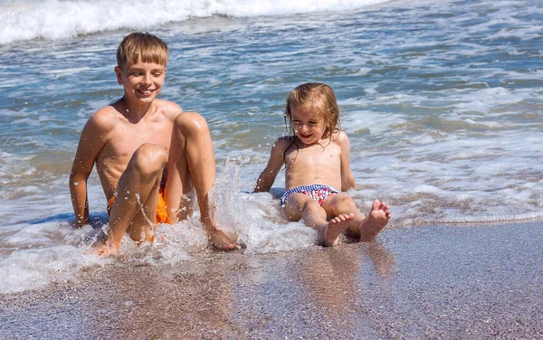 Two Happy Children Boy Girl Sitting Seashore Waves Laughing Happy Stock Image