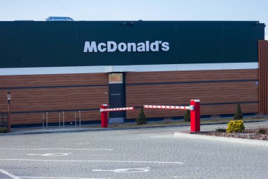 Lviv Ukraine - 03 01 2020:Exterior view of McDonald's fast food restaurant with street tables from the side on a city street and people on the background.