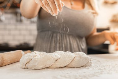 Genç bir kadın mutfakta un ile para kazanıyor.