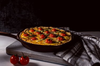 Lorraine kiş açsana. Lezzetli ev yapımı Lorenzo, tavuk, domates, mantar ve peynirli kiş. Karanlık arkaplan, sert gölgeler