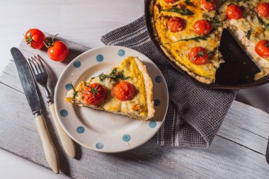 Kiş Lorraine açık kiş. Tabakta dilimlenmiş Fransız Quiche Lorraine turtası çatal bıçak, dökme demir tavada turta. Yukarıdan bak. Düz yatıyordu