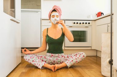 Islak saçlarına havlu sarılmış, kolsuz bluz ve pijama pantolon giyen çekici bir genç kız. Mutfakta nilüfer pozisyonunda oturuyor, kahve fincanı tutuyor ve meditasyon yapıyor. Sabah pozitif duygular