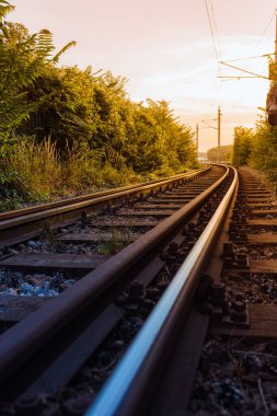 Railway tracks go into distance against backdrop of sunset. Rails and railway go into distance against backdrop of sunset. bolted rails.