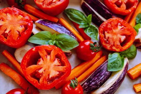 vegetable layout in red colors, fresh vegetables for roasting. Slice of tomato close-up, vegetarian pizza, healthy food