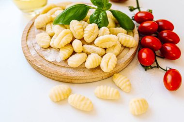 Avusturya mutfağı gnocchi. Tahta tahtada, fesleğen ve domates sosuyla servis edilmiş patates ve un köftesi. Gnocchi için taze gnocchi, domates, zeytinyağı ve patates de dahil.