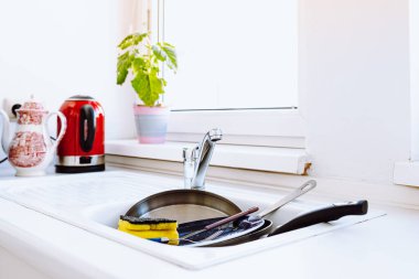 Mutfakta kirli bulaşıkları beyaz cephelerle doldurmuş. Ev aletlerinin tamiri, çalışmayan bulaşık makinesi, su kaynakları, modern ev aletleri.