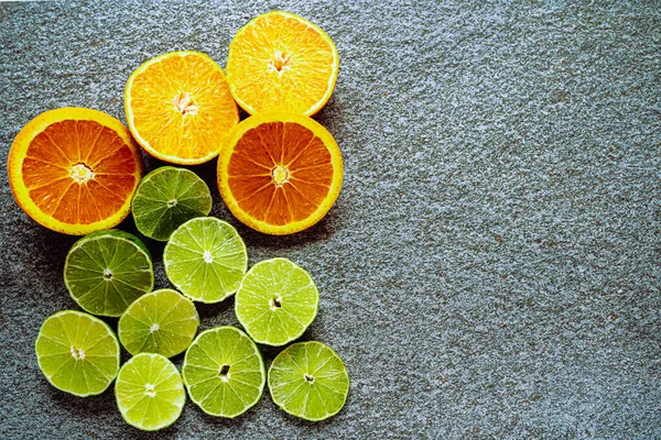 Verschiedene Zitrusfrüchte Und Saftige Limetten Und Orangenscheiben Auf Grauem Steinhintergrund — Stockfoto