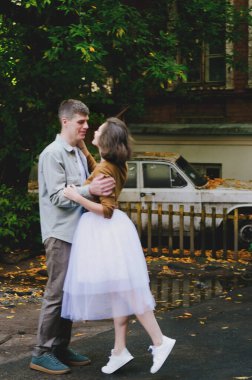 Kharkiv, Ukrayna. 09.19.2021. Tarz sahibi komik bir çiftin aşk hikayesi: tişörtlü genç bir adam. Ve beyaz etekli, sarı kazaklı hoş bir kadın. Aile tatili ve birliktelik, randevu.