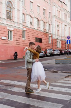 Kharkiv, Ukrayna. 09.19.2021. Tarz sahibi komik bir çiftin aşk hikayesi: tişörtlü genç bir adam. Ve beyaz etekli, sarı kazaklı hoş bir kadın. Aile tatili ve birliktelik, randevu.