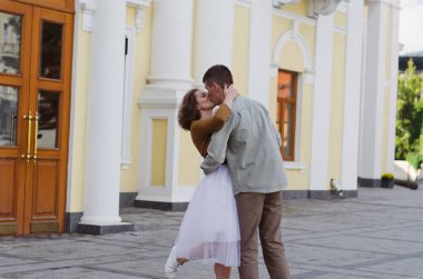 Kharkiv, Ukrayna. 09.19.2021. Tarz sahibi komik bir çiftin aşk hikayesi: tişörtlü genç bir adam. Ve beyaz etekli, sarı kazaklı hoş bir kadın. Aile tatili ve birliktelik, randevu.