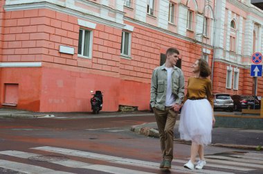 Kharkiv, Ukrayna. 09.19.2021. Tarz sahibi komik bir çiftin aşk hikayesi: tişörtlü genç bir adam. Ve beyaz etekli, sarı kazaklı hoş bir kadın. Aile tatili ve birliktelik, randevu.