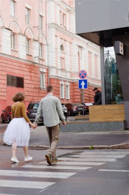 Kharkiv, Ukrayna. 09.19.2021. Tarz sahibi komik bir çiftin aşk hikayesi: tişörtlü genç bir adam. Ve beyaz etekli, sarı kazaklı hoş bir kadın. Aile tatili ve birliktelik, randevu.