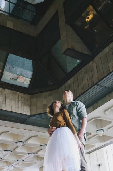 stock image Kharkiv, Ukraine. 09.19.2021. Love story of stylish funny couple: young man in a t-shirt. And a cute young woman in wedding white skirt and yellow sweater. Family holiday and togetherness, date.