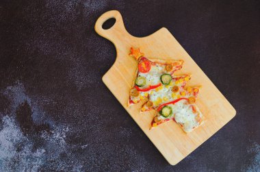 Siyah arka planda domatesli, sebzeli ve peynirli lezzetli vejetaryen Noel ağacı pizzası. Yaratıcı, çocuklar için komik yemek konsepti. Üst manzara, düz yatış. Boşluğu kopyala. 
