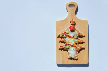 Beyaz arka planda domatesli, sebzeli ve peynirli lezzetli vejetaryen Noel ağacı pizzası. Yaratıcı, çocuklar için komik yemek konsepti. Üst manzara, düz yatış. Boşluğu kopyala. 