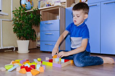 Küçük çocuk, okullu çocuk evde oyuncak renkli tahta bloklarla oynuyor. Mutlu aile hayatı, hobi ve eğlence.. 