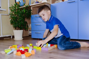 Küçük çocuk, okullu çocuk evde oyuncak renkli tahta bloklarla oynuyor. Mutlu aile hayatı, hobi ve eğlence.. 
