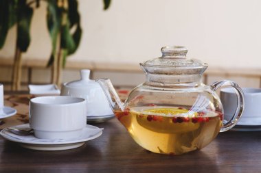 Cam çaydanlığın en üst görüntüsü ve restorandaki bir masada bir fincan çay. Çay seremonisi. Tatil konsepti. Sıcak kış içecekleri. 