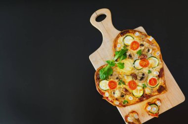 Arka planda Sevgililer Günü için domatesli, sebzeli ve peynirli kalp şeklinde pizza. Romantik aşkın yaratıcı yemek konsepti. Üst manzara, düz uzanma.
