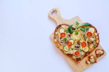 Arka planda Sevgililer Günü için domatesli, sebzeli ve peynirli kalp şeklinde pizza. Romantik aşkın yaratıcı yemek konsepti. Üst manzara, düz uzanma.