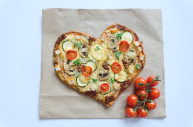 Arka planda Sevgililer Günü için domatesli, sebzeli ve peynirli kalp şeklinde pizza. Romantik aşkın yaratıcı yemek konsepti. Üst manzara, düz uzanma.