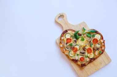 Arka planda Sevgililer Günü için domatesli, sebzeli ve peynirli kalp şeklinde pizza. Romantik aşkın yaratıcı yemek konsepti. Üst manzara, düz uzanma.