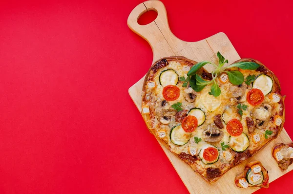 Arka planda Sevgililer Günü için domatesli, sebzeli ve peynirli kalp şeklinde pizza. Romantik aşkın yaratıcı yemek konsepti. Üst manzara, düz uzanma.