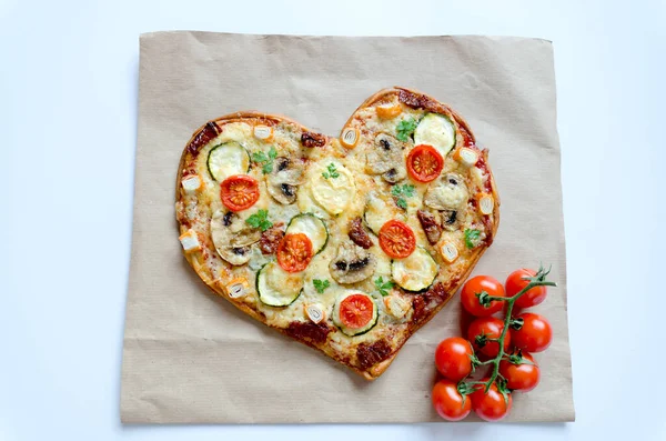 Arka planda Sevgililer Günü için domatesli, sebzeli ve peynirli kalp şeklinde pizza. Romantik aşkın yaratıcı yemek konsepti. Üst manzara, düz uzanma.