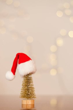 Kırmızı Noel Baba şapkası oyuncak Noel ağacının üstünde, arka planda bokeh var. Üst Manzara. Yeni yıl havası. Tebrik kartı. Parti ve tatil kutlaması konsepti.
