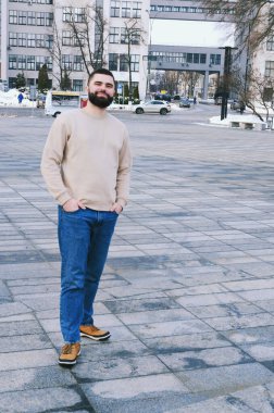 Kışın günlük kıyafetler, ceket, şapka giymiş zarif bir iş adamının şehir portresi. Şehir caddesinde yürümek, telefonda konuşmak, selfie çekmek. Açık havada çalışmak.