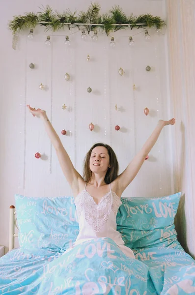 若い幸せな笑顔の女性 花嫁はパジャマ 居心地の良い家のバスローブのベッドに横たわっています 飲料水だ 落ち着いて 健康的なライフスタイル 朝の儀式 — ストック写真