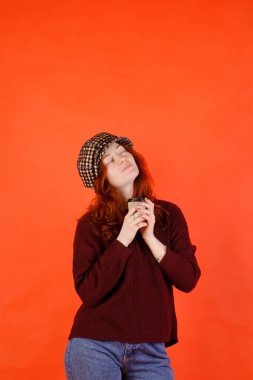 Renkli arka planda kırmızı kıvırcık saçlı ve mavi gözlü güzel bir genç kadının iş portresi. Yaşam biçimi. 