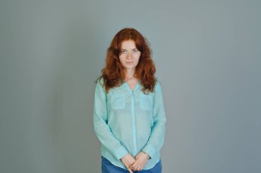 Renkli arka planda kırmızı kıvırcık saçlı ve mavi gözlü güzel bir genç kadının iş portresi. Yaşam biçimi. 