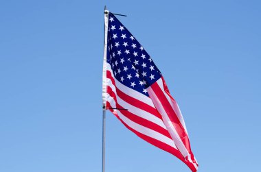 Portoroz, Slovenya. 06.12.2022. Amerikan Bayrağı dalgalanıyor mavi gökyüzüne, ABD Bayrağı dalgalanıyor. 