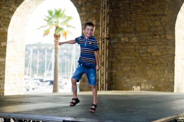 Mutlu aile hayatı ve tatil konsepti. Anne, küçük oğlan, kız, scooter 'a biniyor, eski şehirde, sokakta yürüyor. - Dondurma. Güneşli bir yaz gününde gülüyorlar. Eğleniyorum.