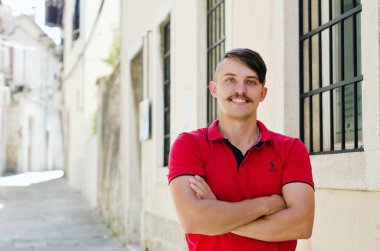 Koper, Slovenya. 25.06.2022. Genç ve yakışıklı sakallı adam, eski Koper şehrinde yürüyen bir turist. Yaz tatili. Güneş gözlüğü. Yaşam tarzı portresi